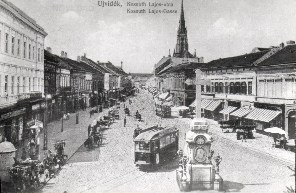 Ujvidék, Kossuth Lajos utca — vue de la rue avec tramway et monument — éditeur inconnu - Recto