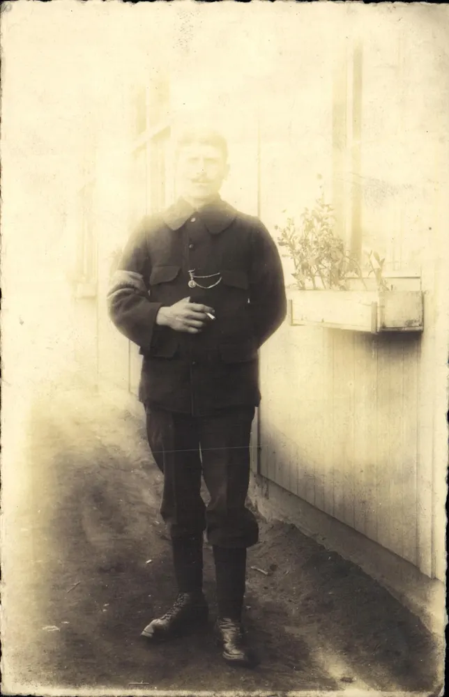 Soldat en uniforme — portrait en extérieur près d'un mur avec bac à fleurs — éditeur non visible - Frente
