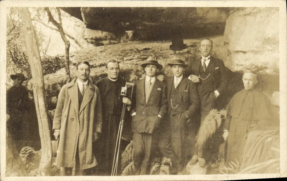 Gruppe von Personen vor einer Höhle - Vorderseite