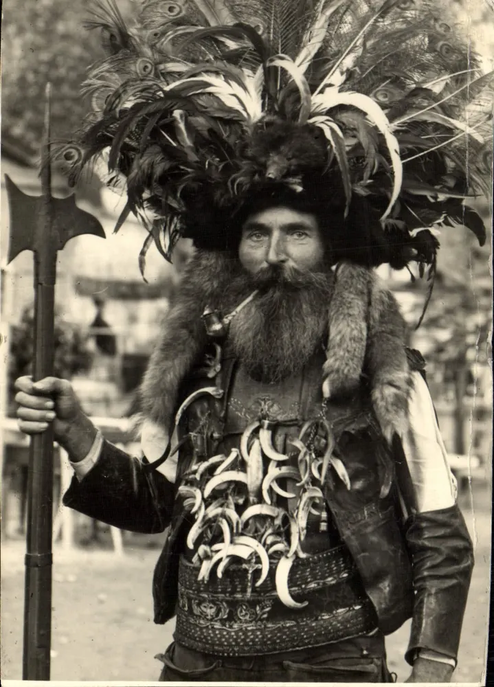 Homme en costume de guerrier — coiffe de plumes de paon, armure ornée de sabots — éditeur: Fotografo e F. Ligure, Milan - Frente