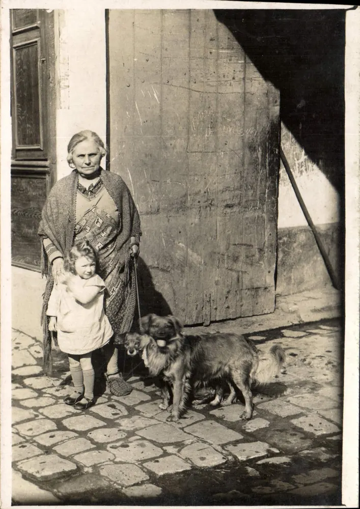 Frau und Kind mit zwei Hunden — vor einer Holztür — Seriennummer nicht sichtbar - Vorderseite