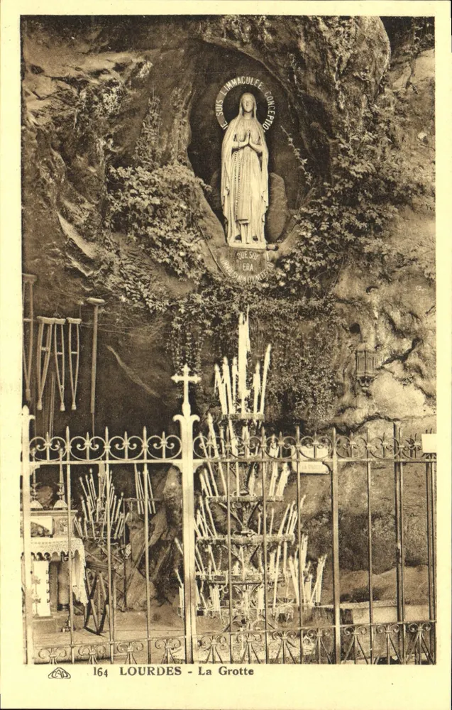 Lourdes - A Grotta — estátua da Nossa Senhora de Lourdes em uma gruta, com moldura metálica e velas - Frente