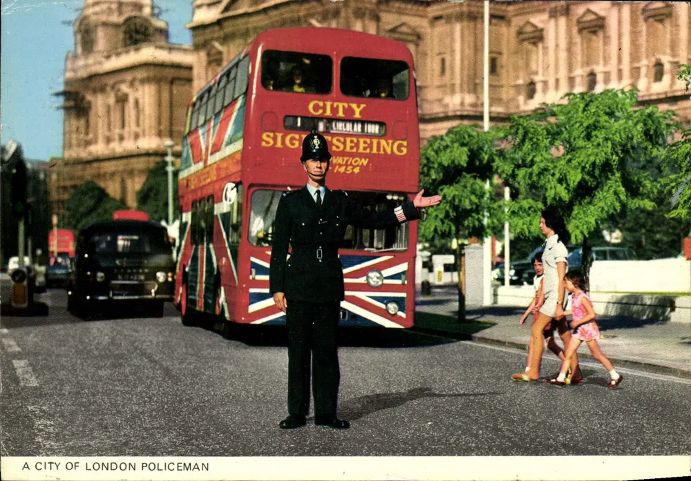 A City of London Policeman — devant un bus touristique rouge — éditeur Photo Precision Limited - Frente