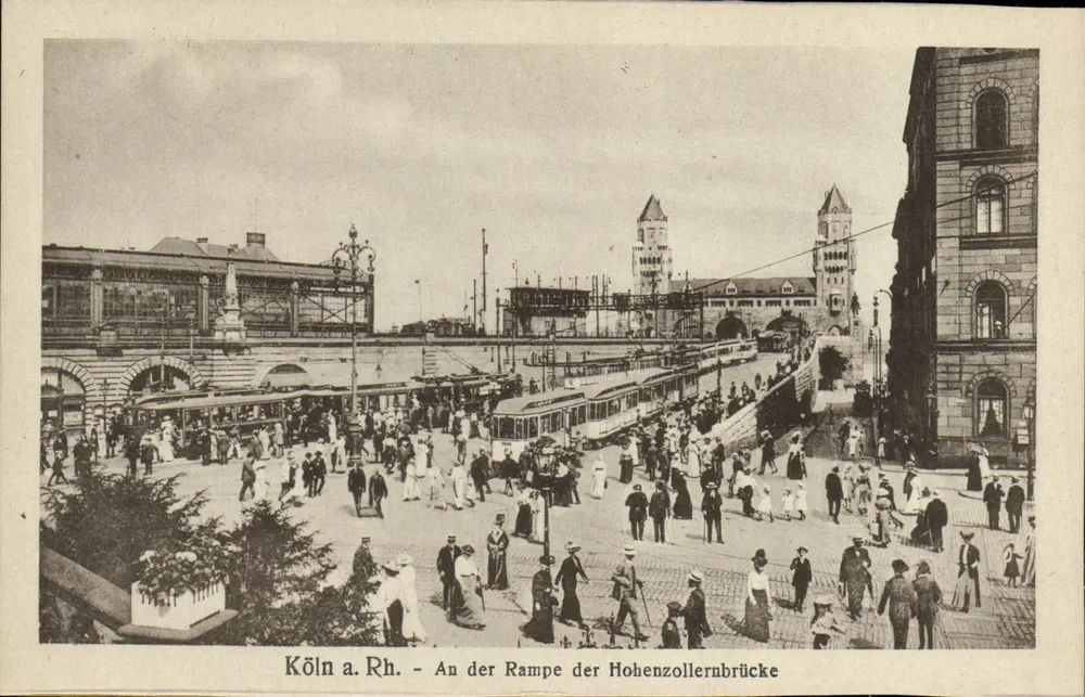 Köln a. Rh. - An der Rampe der Hohenzollernbrücke — Ansicht der Rampe der Hohenzollernbrücke mit Straßenbahn und Menschenmenge - Vorderseite