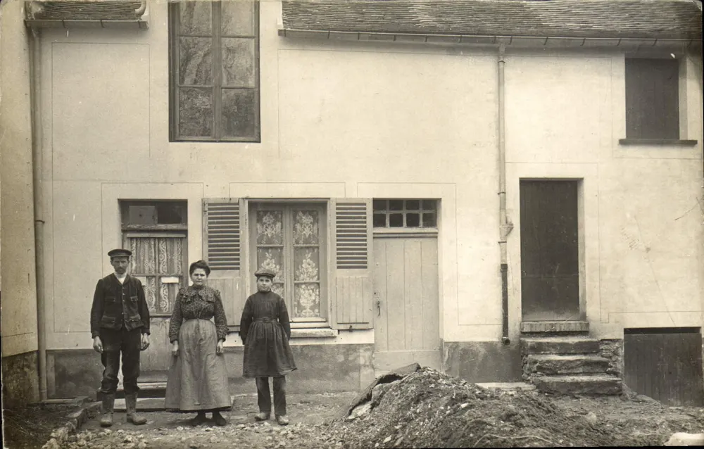 Tres personas frente a una casa — Champigny-sur-Marne — editor BLANC, n° 654 - Anverso