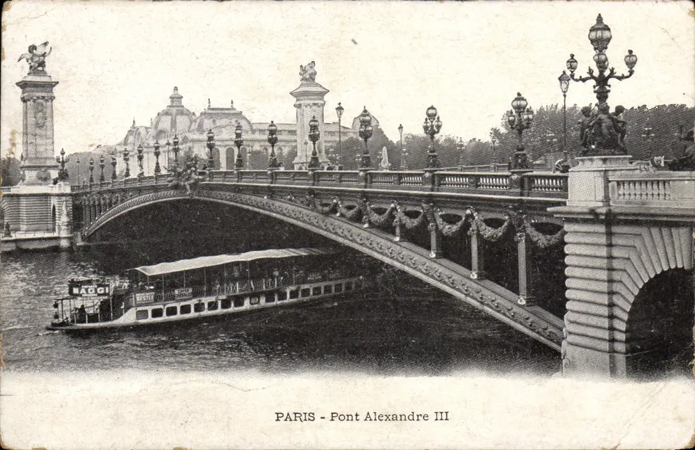 Paris - Pont Alexandre III — vue du pont orné de guirlandes avec un bateau NAGGI en dessous, éditeur IMPRIMÉ SUR LA CARTE - Frente