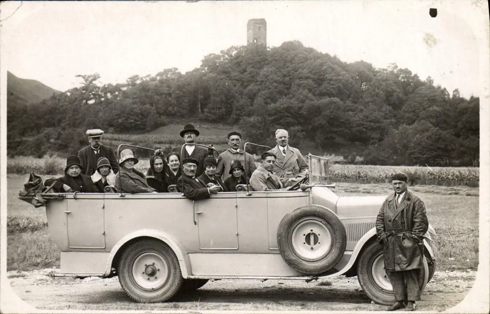 Grupo em um automóvel — Tour de castelo no fundo — Editor não identificado - Frente