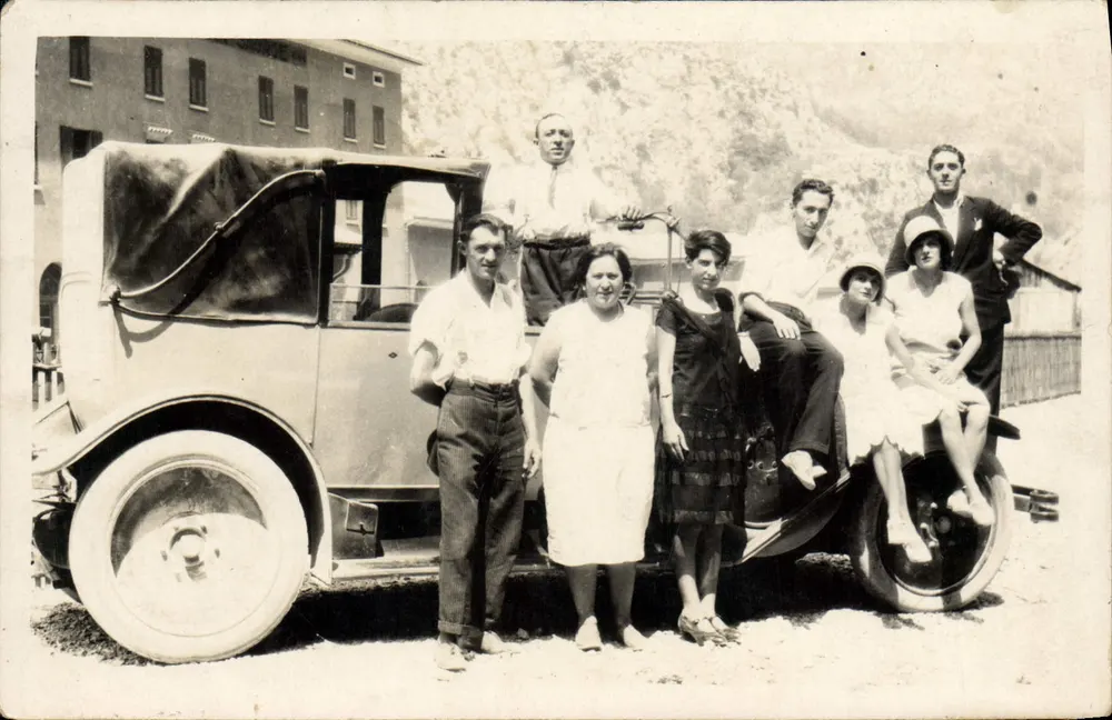 Grupo de pessoas diante de um automóvel antigo — número de série 13 - Frente