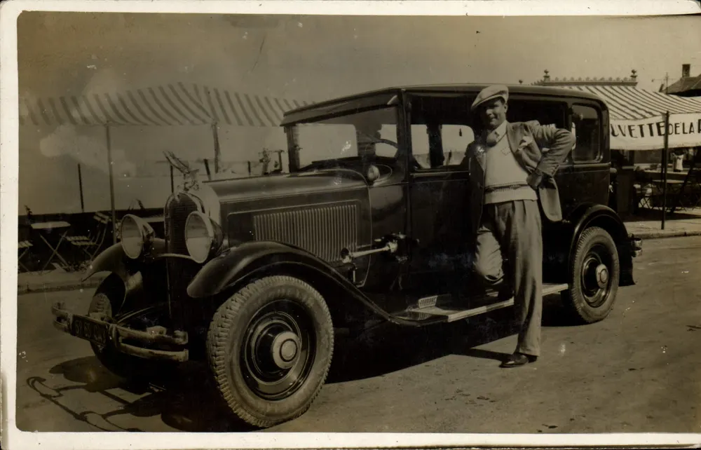 Homem diante de um automóvel — número de série não visível - Frente