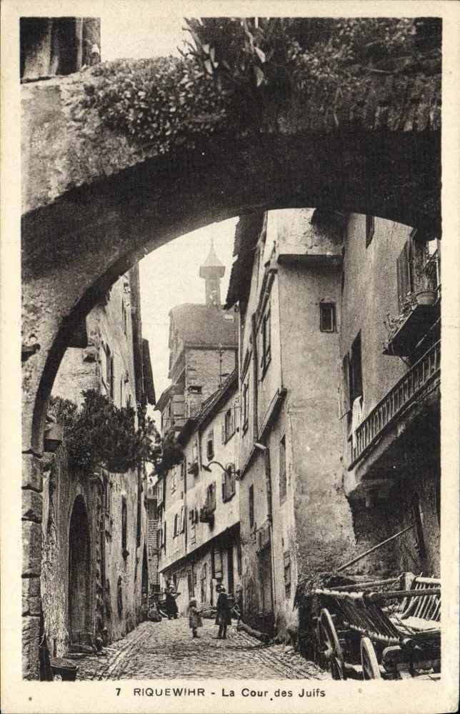 Riquewihr - Der Judenhof — Ansicht unter einem Steinbogen mit gepflasterten Straße und alten Gebäuden - Vorderseite