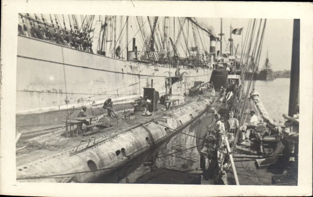 Submarino no cais — entre grandes embarcações — - Frente
