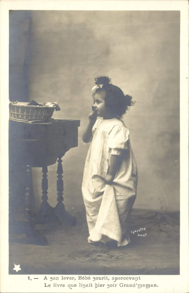 Baby lächelt — Beim Aufwachen lächelt Baby, sieht das Buch, das Grandma gestern Abend las — CLAYETTE PHOT. - Vorderseite