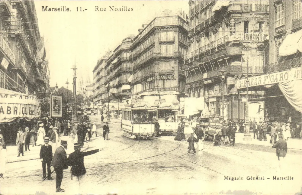Marselha. 11.- Rue Noailles — vista da rua com trêm e comércios — Magasin Général - Marselha - Frente