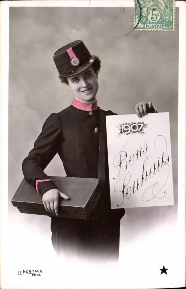 Posto francês — Mulher em uniforme segurando um cartaz 'Bons Souhaços 1907' — Le Normand Phot. - Frente
