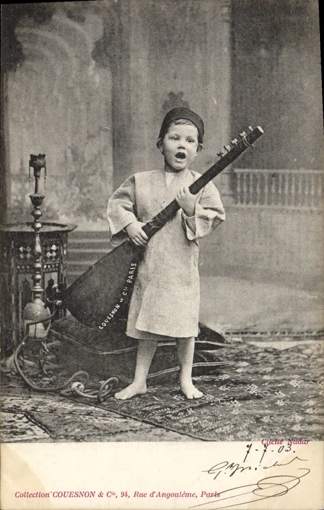 Criança vestindo traje oriental tocando um instrumento — Coleção COUESNON & Cie, Rue d'Angoulême, Paris - Frente