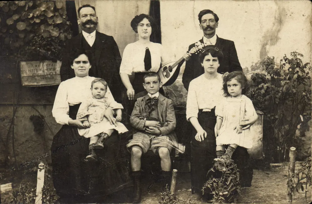 Família — diante de um muro com placa 'BASTIÈRE PATEMENTAL COLOMBE' — editor desconhecido - Frente