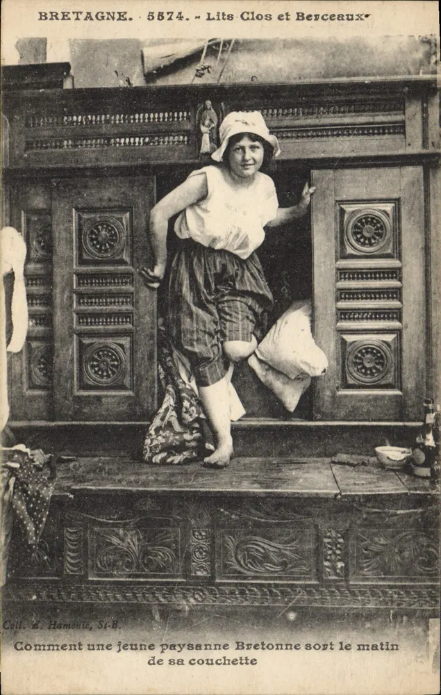 Bretagne. 5574. - Lits-Clos und Berceaux. Wie eine junge bretonische Bauernfrau am Morgen aus ihrem Bett steigt - Vorderseite