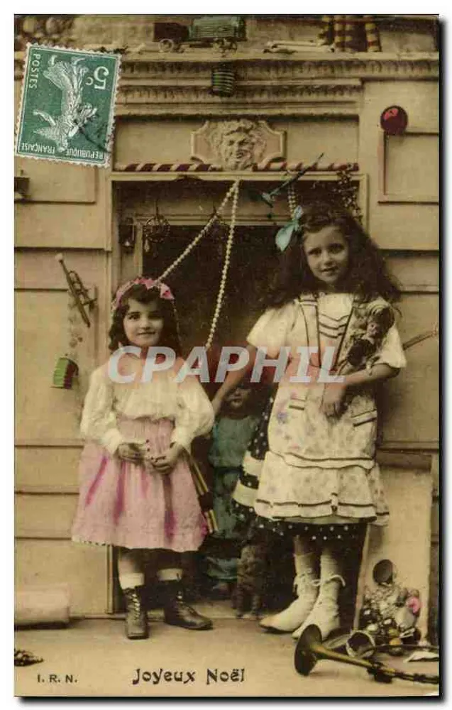 Duas meninas diante de uma porta decorada — Feliz Natal — I.R.N. - Frente