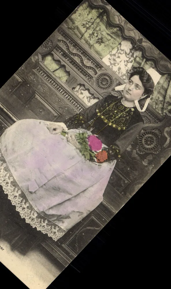 Mulher em vestido escuro e véu branco — segurando um buquê de flores — editor 'Cramer' (parcialmente visível) - Frente