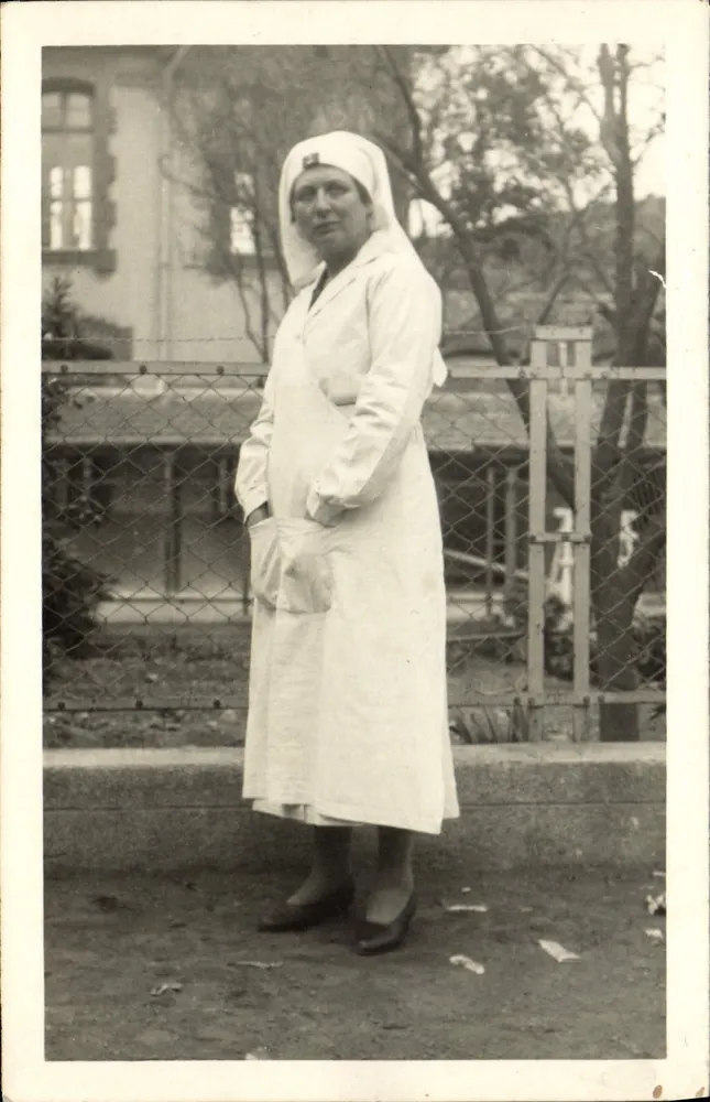 Schwester — in weißer Uniform vor einem Zaun — Nr. 5 - Vorderseite
