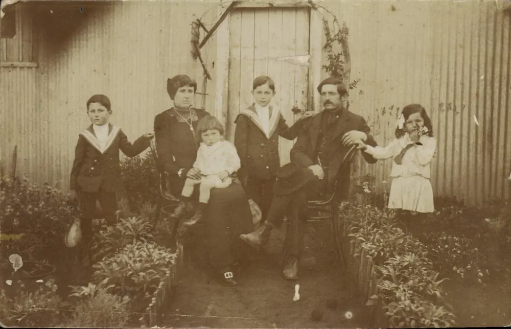 Familie vor einer Wellblechzaun — Republik Argentinien - Vorderseite