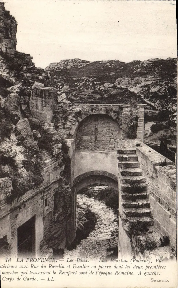 लेस बॉउएक्स — रूड़ डू रावेलिन और पत्थर के सीढ़ियों के साथ आंतरिक दृश्य, जिनके पहले दो सीढ़ियाँ रोमन दीवार के माध्यम से गुजरती हैं। — SELECTA - आगे