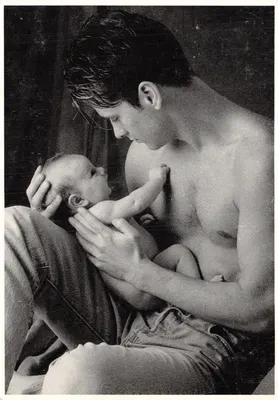 Um homem amamentando um bebê — cena íntima em preto e branco — editor Fitting Image, n° 64714