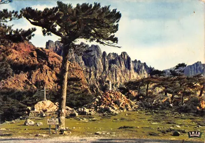 Col de Bavella — paysage montagneux avec croix et panneau — éditeur IRIS