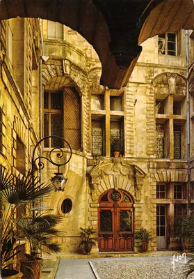 Hôtel de Sarret dit de la Coquille — cour interior com porta de madeira e lanternas — Éditions J. Jaules de P. E. M.
