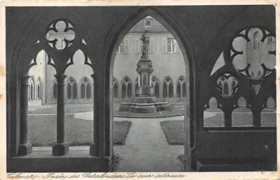 Colmar - Musées des Unterlinden. La cour intérieure — vue encadrée par des arcades gothiques ornées de rosaces