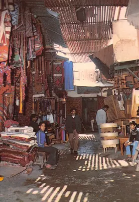 Marché aux tapis de Marrakech — scène animée sous une toiture en bois — éditeur DIFIKOT s.a.r.l