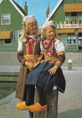 Deux jeunes filles en costume traditionnel néerlandais — devant un restaurant au bord du port — éditeur gebr. spanjersberg, n° M 28