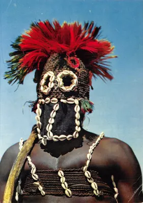 Masque africain Dogon — porteur de masque orné de coquillages et de plumes rouges — éditeur MEXICHROME, n° 3718