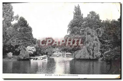 PARIS - Les Buttes-Chaumont — widok jeziora z mostkiem i drzewami —