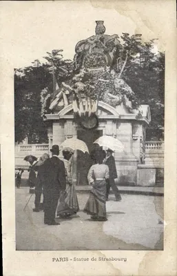 Paryż — Statua Strasburga — monument ozdobiony wiankami i dekoracjami, z odwiedzającymi pod parasolami