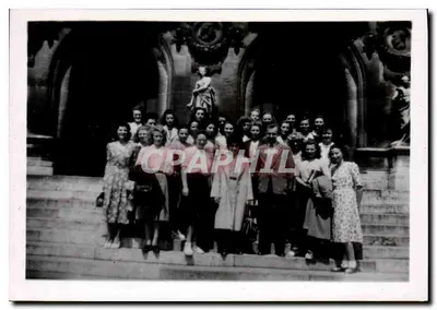 Grupo de jovens mulheres — diante de um edifício com arcadas — sem editor ou número visível