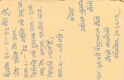 Cartolina di risposta indiana — testo manoscritto in devanagari — timbro e filigrana postale — Verso