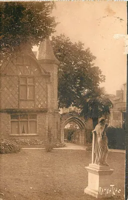 Jardim público de Châtellerault — vista de uma casa no estilo Tudor com estátua — editor Ramuntcho