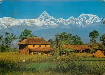 Paisagem nepalesa — montanhas nevadas e cabanas com telhados de palha — editor não visível