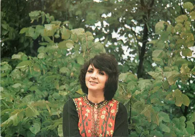 Mulher sorridente em traje colorido — fundo vegetal — Agencja Wydawnicza Halina Kunicka, série 54-586