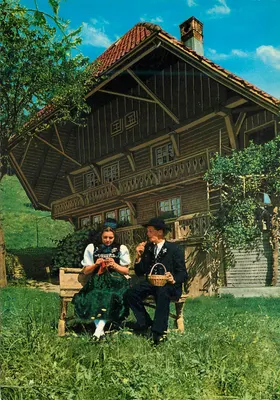 Casal em traje tradicional — diante de uma casa de madeira — Krüger 1036/45