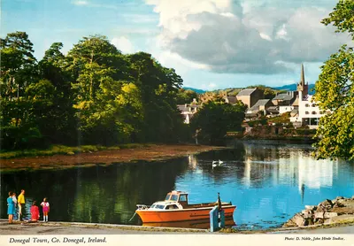 Donegal Town, Co. Donegal, Irlanda — vista do porto com barco e igreja — Foto D. Noble, John Hinde Studios