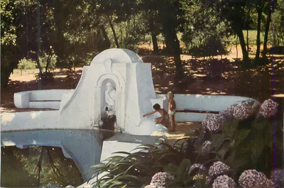 Fonte com estátua — parque arborizado — crianças brincando — editor não visível