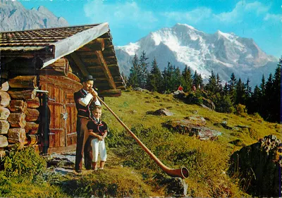 Alpinista e criança com cor de bico — diante de cabana de troncos — Alpes suíços