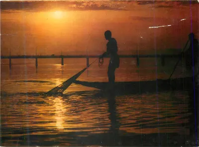 Pescador ao pôr do sol — silhueta em um lago — editor não identificável