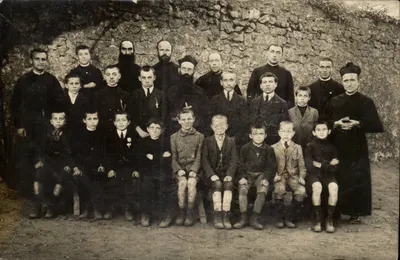 Grupo de religiosos e crianças — diante de um muro de pedra — editor desconhecido
