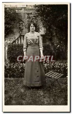 Mulher no jardim — diante de uma parede vegetal — carta postal