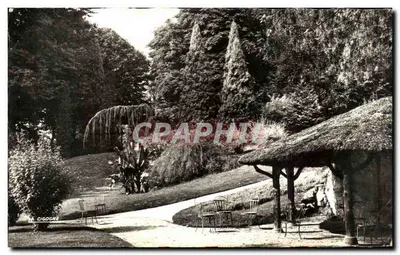 Jardin de la Cigogne — Vue d'un parc avec cabane à toit de chaume et allée — Éditions Cigogne