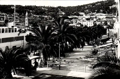 Praia e cais da ilha de Hvar — vista com ferry e palmeiras — editor não visível