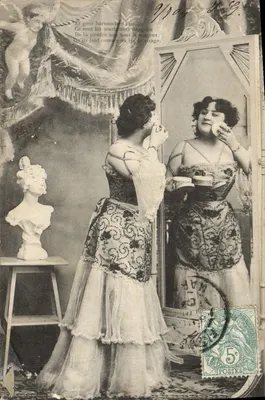 Mulher se maquilando diante de um espelho — decoração com busto e cortinas — editor não identificado